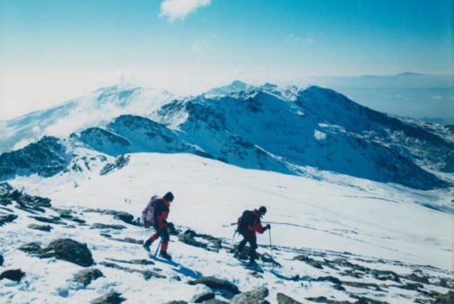 Antonio y Jesús bajando a La Carihuela, dicho collado a la izquierda, el centro a la izquierda los Tajos de La Virgen y Pico del Tajo de Los Machos detrás entre nubes, en el centro Elorrieta y Caballo detrás, a la derecha Cartujo y al fondo la Sierra de Tejeda