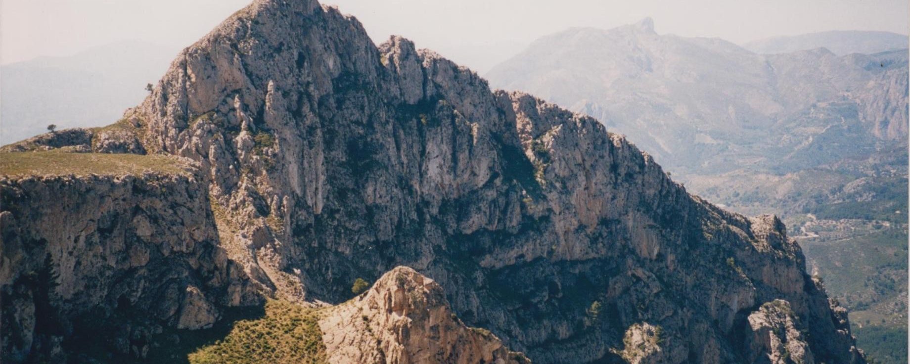 Bajando del Coll de l’Orenga, 819 mts, al fondo casi invisible la Sierra de L’Aixortà con su pico más alto Penya Alta o Cerro de Los Parados