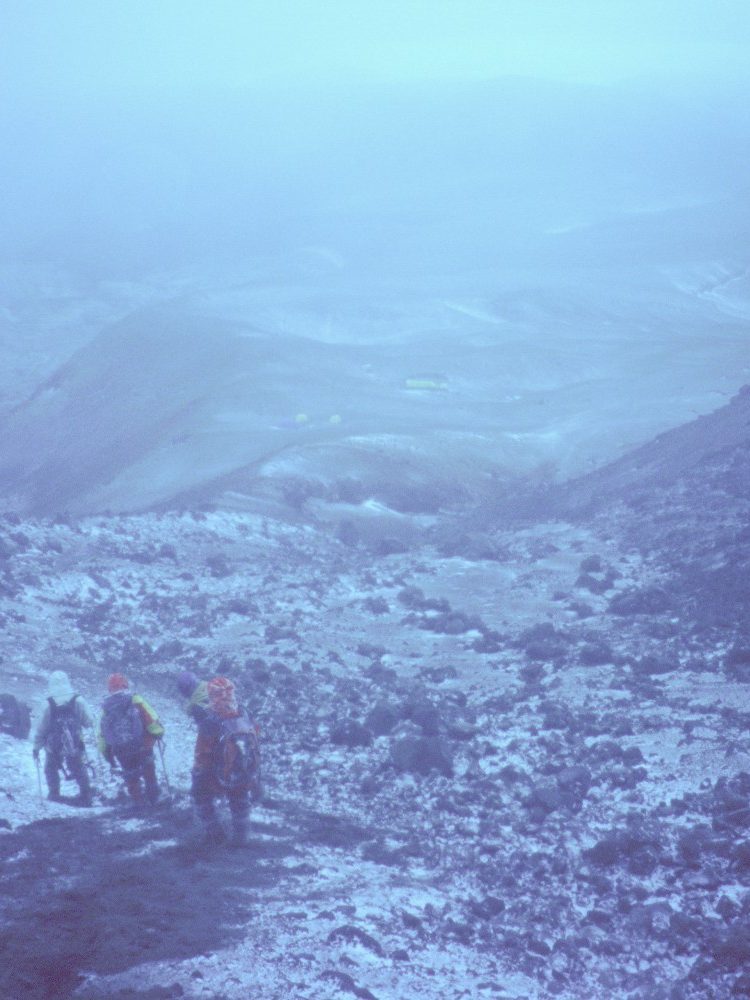 Bajando al campo alto de la cara sur del Cotopaxi con Viento Blanco. Las carpas del campo alto en el centro de la ladera menos nevada